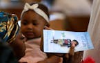 A woman holds a program at a celebration of life service for Le'Vonte King Jason Jones, 2, shot and killed last week in a drive-by shooting, during a 