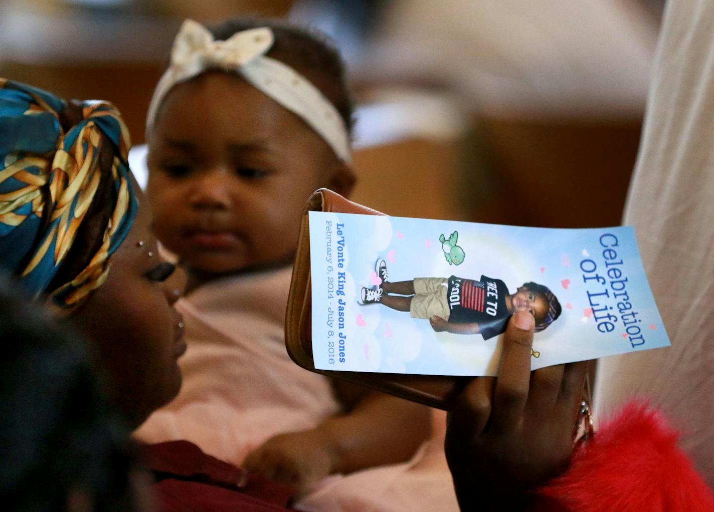 A woman holds a program at a celebration of life service for Le'Vonte King Jason Jones, 2, shot and killed last week in a drive-by shooting, during a celebration of life service Friday, July 15, 2016, at Bethel Christian Fellowship.](DAVID JOLES/STARTRIBUNE)djoles@startribune Celebration of Life for Le&#x201d;Vonte King Jason Jones, 2, Friday, July 15, 2016, at Bethel Christian Fellowship. Jones was shot and killed in a drive-by shooting on July 8, in North Minneapolis.