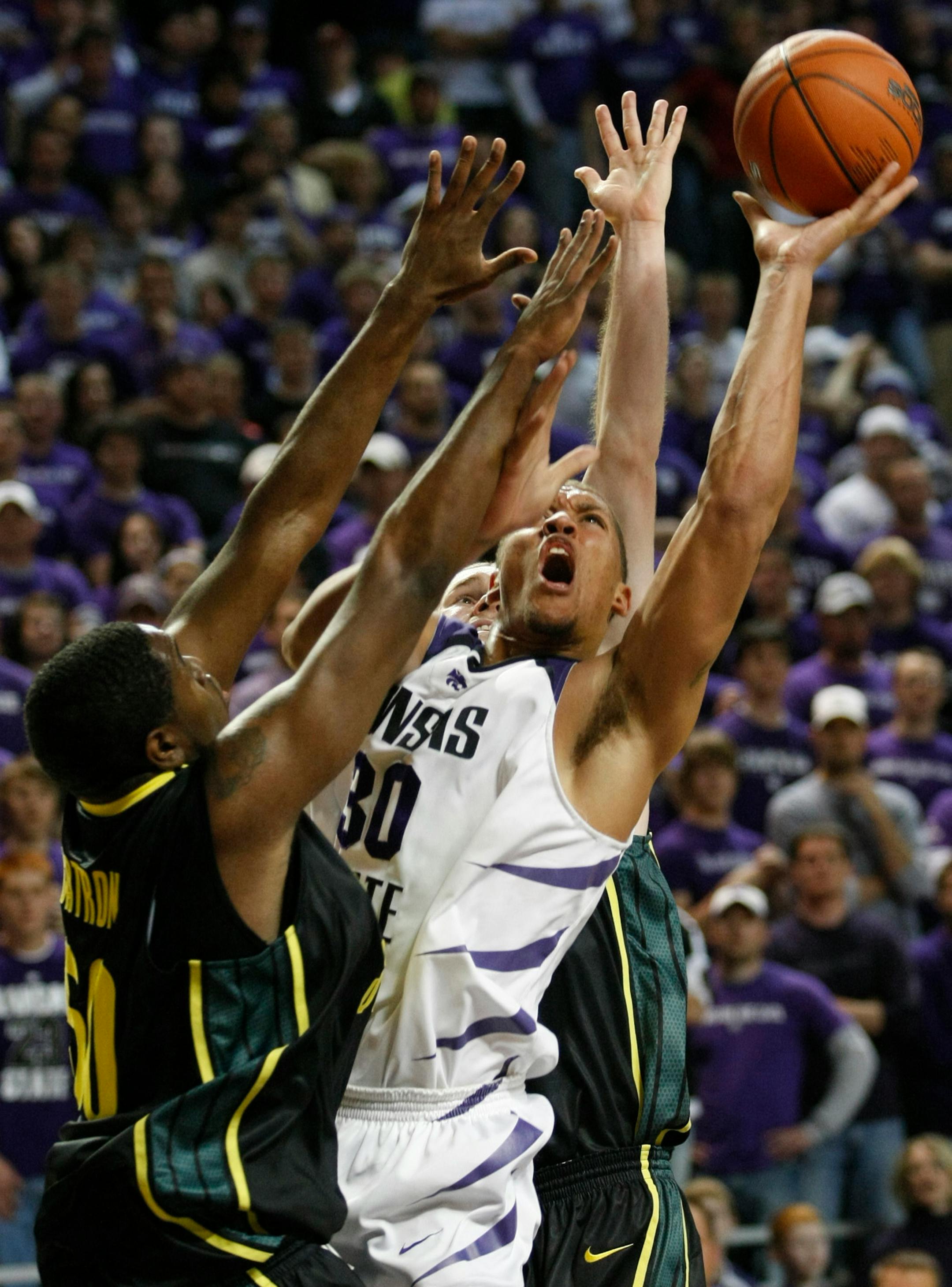 Kansas State's Michael Beasley goes up for a shot over Oregon's Maarty Leunen, back, and Joevan Catron, left, in the first half on Thursday, November 29, 2007, at Bramlage Coliseum in Manhattan, Kansas. (Travis Heying/Wichita Eagle/MCT)