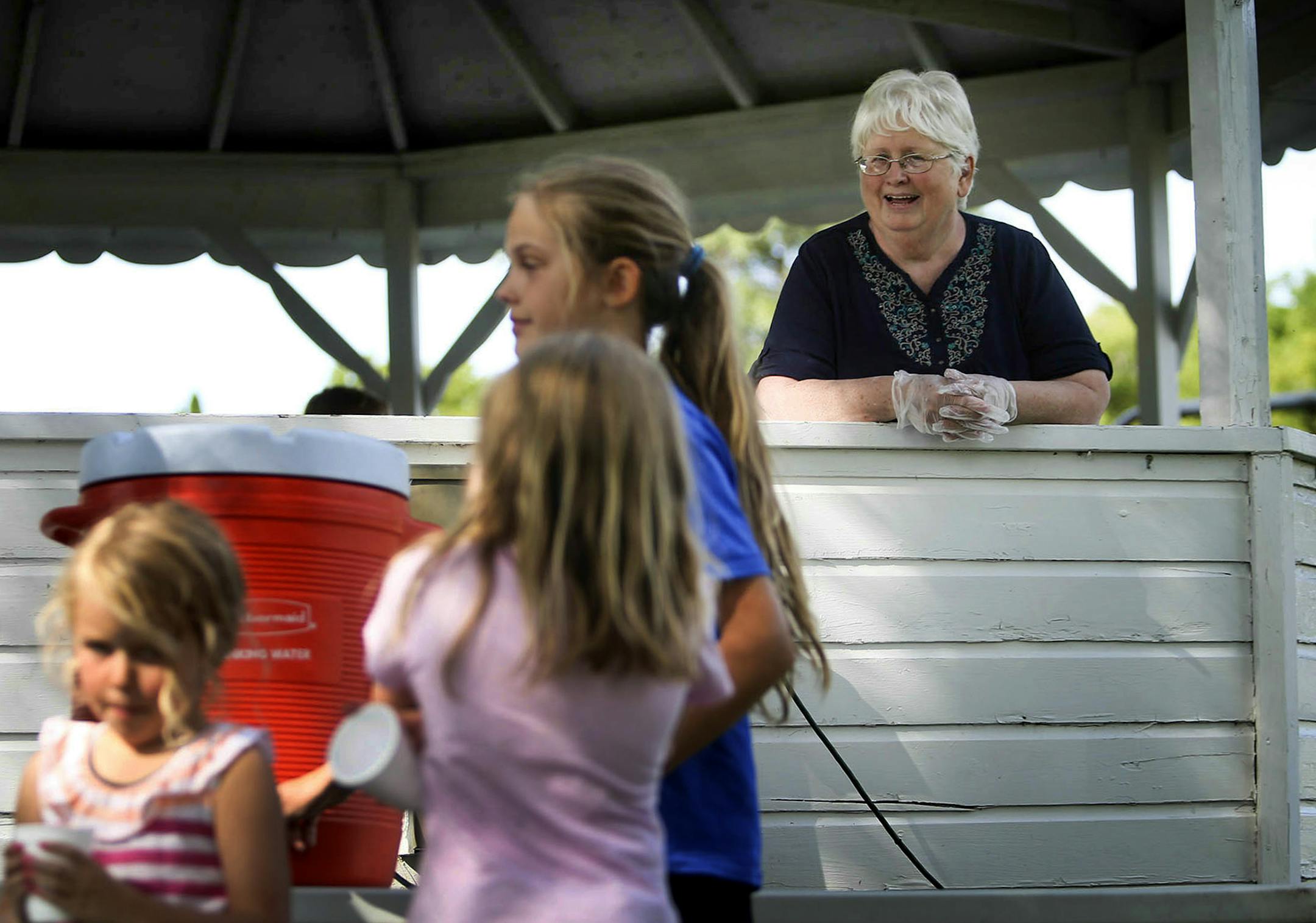 Hoffman resident and town catalyst Muriel Krusemark, 73, rear right, watches residents at the weekly Hoffman flea market in the main town park Wednesday, July, 16, 2014, in Hoffman MN.] (DAVID JOLES/STARTRIBUNE) djoles@startribune When Muriel Krusemark, 73, moved back to her hometown of Hoffman, Minn., there were few open storefronts on Main Street. But since she became the part-time economic development director, each vacant space has been filled. It's a trick that many small towns across the M