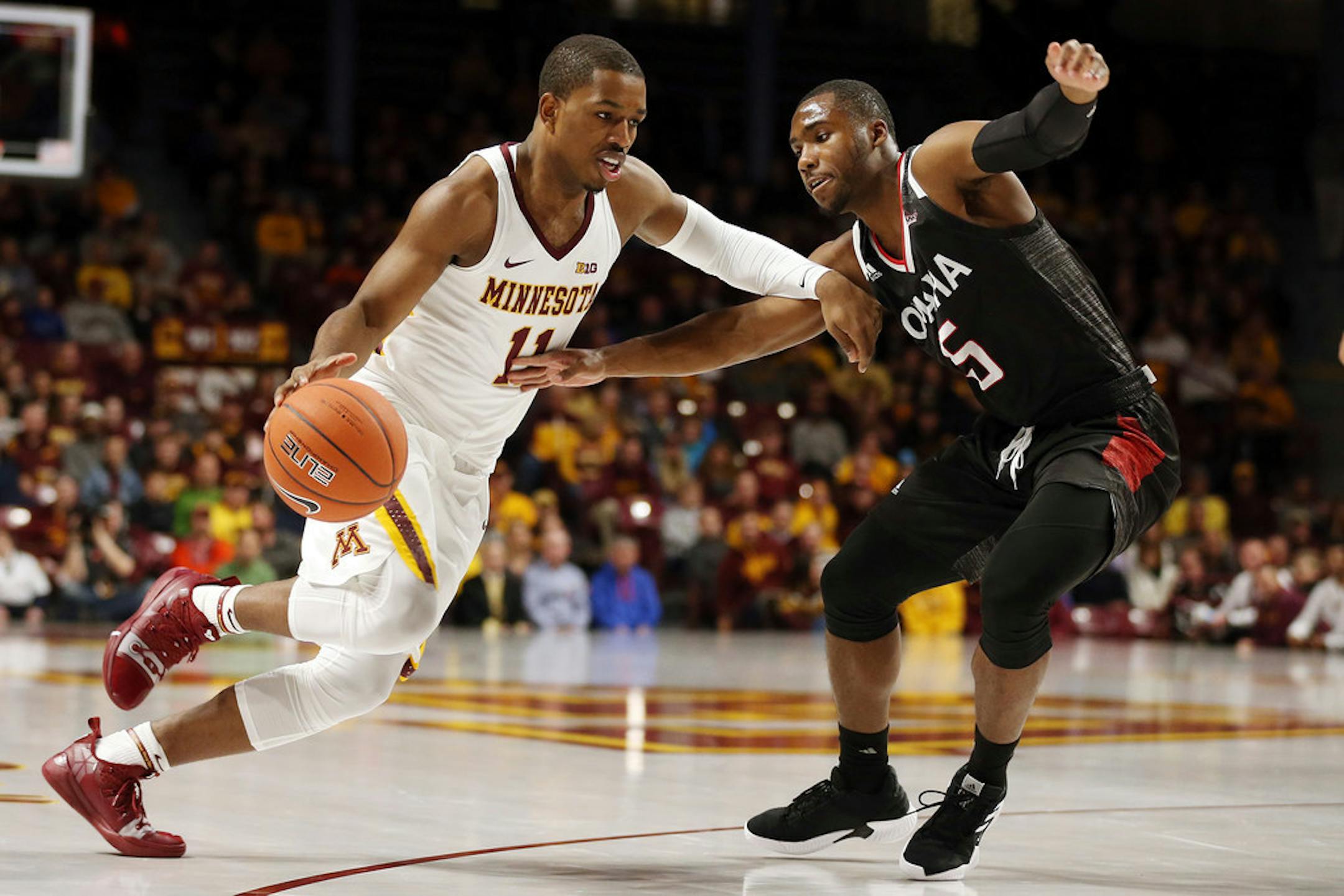 Minnesota's Isaiah Washington (11) drives the ball around Nebraska-Omaha's KJ Robinson (5) during an NCAA college basketball game Tuesday, Nov. 6, 2018, in Minneapolis. (AP Photo/Stacy Bengs)