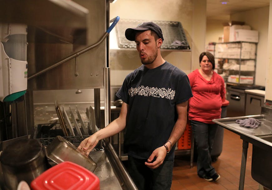 Like thousands of other high school graduates in Minnesota, Chris McIntire went straight to work at a segregated workshop, where he did menial factory work for sub minimum wages. Then in 2017, the state Vocational Rehabilitation program stepped in and found Chris a job for $10/hour at Friendly Buffalo Restaurant in Big Lake, Minn. Here, McIntire whistles to the Bob Dylan song The Times They Are a Changing', while washing dishes with his job coach Jaime Klatt looking on Friday, May 11, 2018, at t