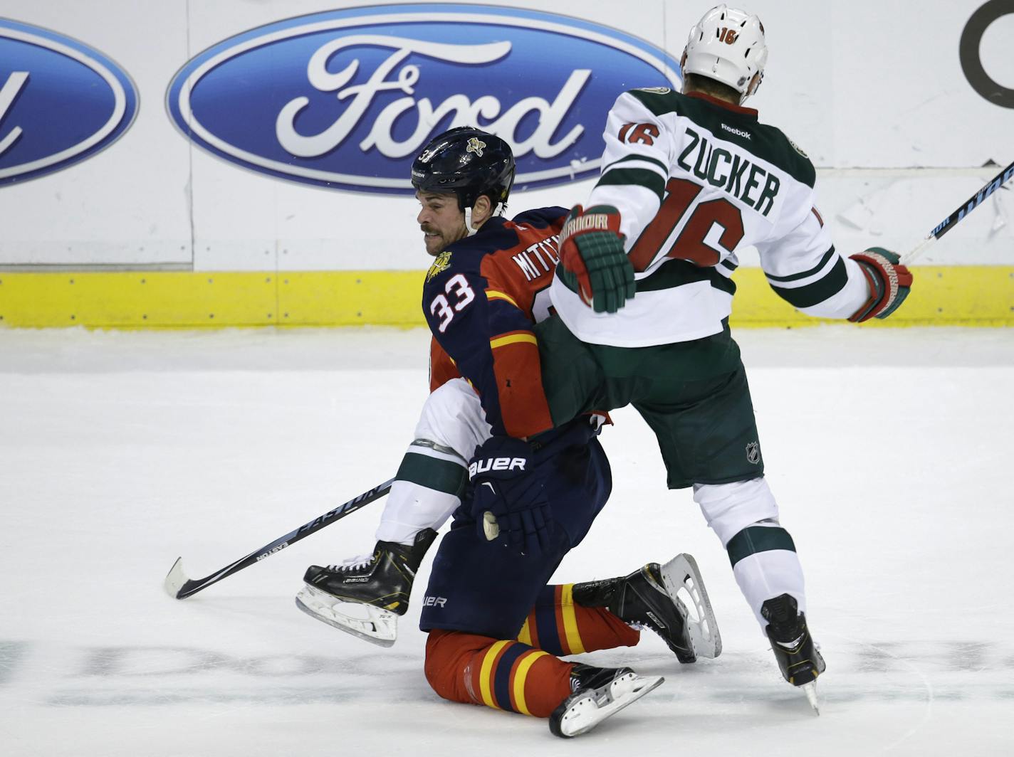 Minnesota Wild left wing Jason Zucker (16) gets tangled up with Florida Panthers defenseman Willie Mitchell (33) during the second period of an NHL hockey game, Monday, Nov. 24, 2014, in Sunrise, Fla.(AP Photo/Lynne Sladky)