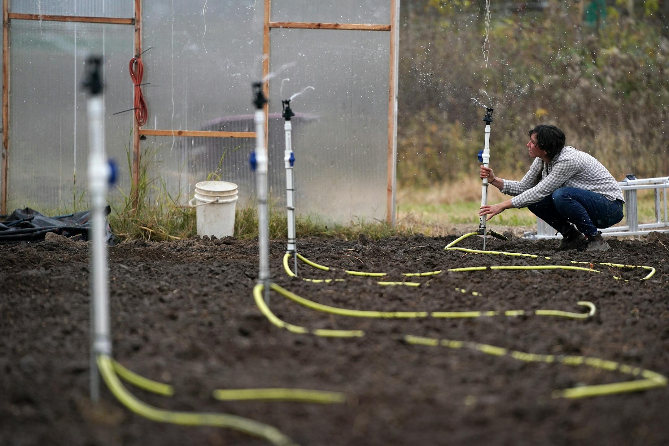 Vegetable farmer Kristin Pearson adjusted the irrigation system in one of her two greenhouses at her rented land.