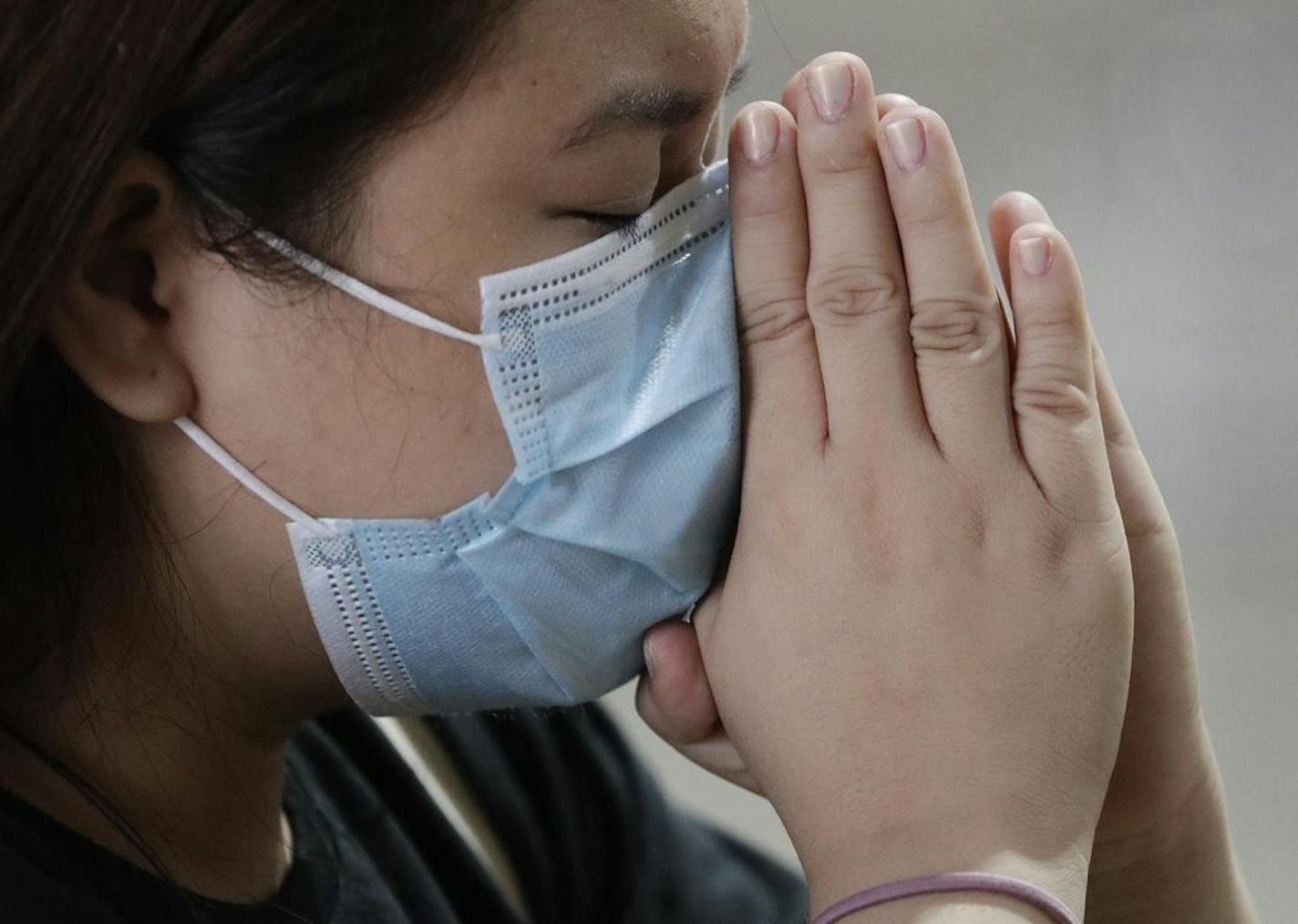 A Catholic woman wearing a face mask prays during a mass in Manila, Philippines.