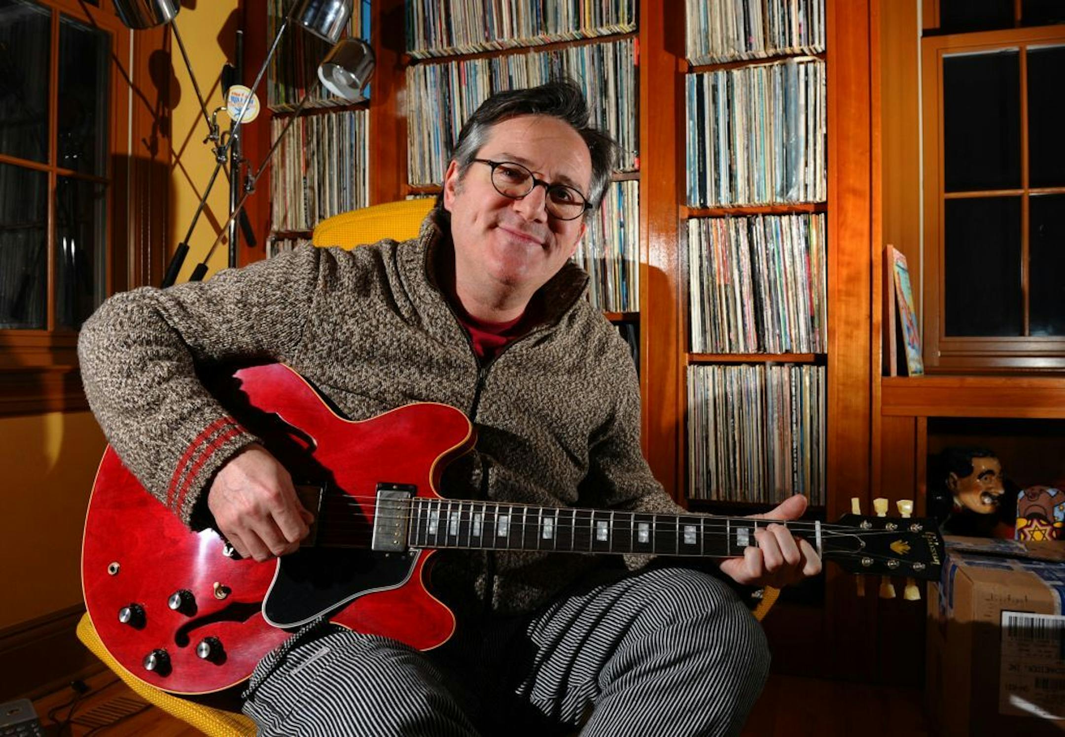 FILE - In this Jan. 11, 2013, file photo, David Schneider poses with his new custom Gibson guitar at his home in Fairfield, Conn. It was given to him by Gibson after hearing of his plight of a broken Gibson guitar due to baggage handlers at Delta Airlines.