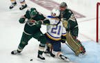 St. Louis Blues' Tyler Bozak (21) is double-teamed by Minnesota Wild's Jon Merrill, left, and Marc-Andre Fleury during the third period of Game 2 of a