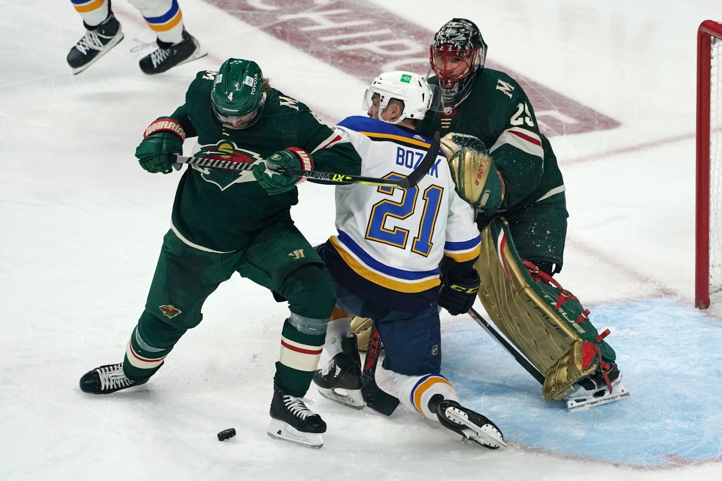 St. Louis Blues' Tyler Bozak (21) is double-teamed by Minnesota Wild's Jon Merrill, left, and Marc-Andre Fleury during the third period of Game 2 of an NHL hockey Stanley Cup first-round playoff series Wednesday, May 4, 2022, in St. Paul, Minn. The Wild won 6-2. (AP Photo/Jim Mone)