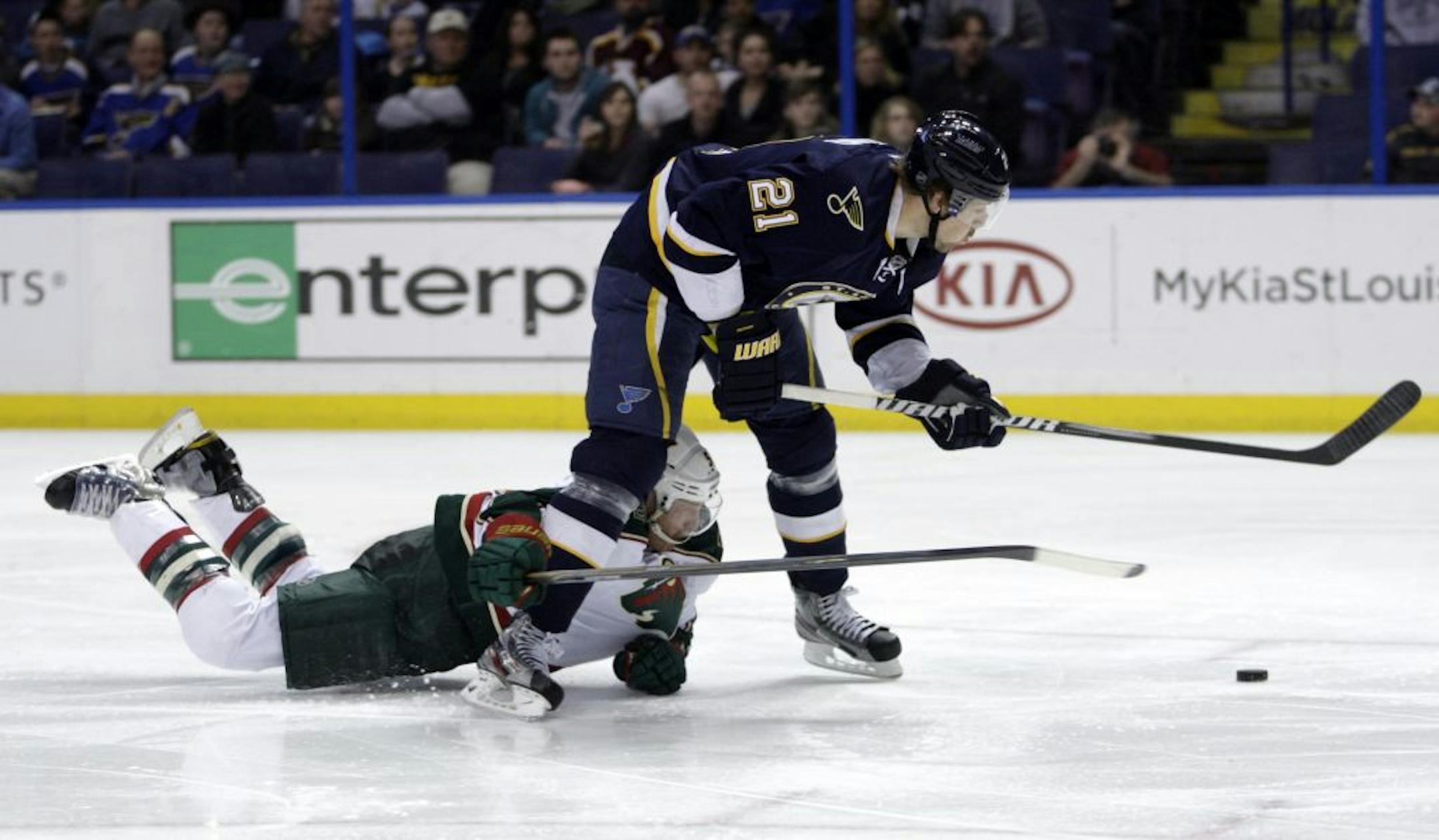 Minnesota Wild's Greg Zanon (5) trips St. Louis Blues' Patrik Berglund (21) while on a a breakaway, drawing a penalty shot, in the second period of an NHL hockey game, Saturday, Feb. 18, 2012 in St. Louis.