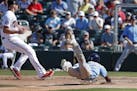 Tampa Bay Rays' Randy Arozarena slides into home plate to score on a passed ball as Minnesota Twins pitcher Trevor May, left, looks for a throw during