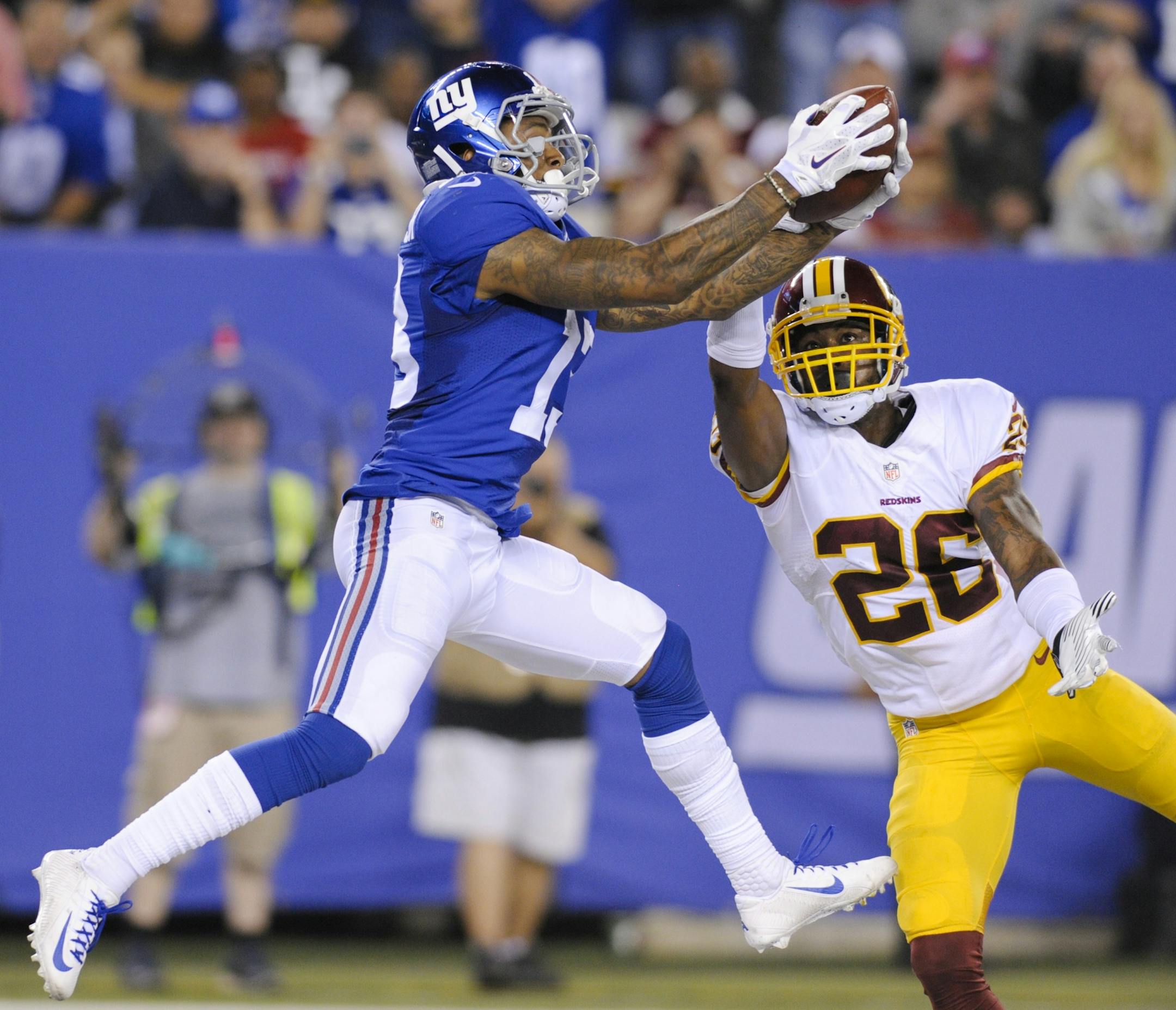 New York Giants wide receiver Odell Beckham (13) catches a pass for a touchdown in front of Washington Redskins' Bashaud Breeland (26) during the second half an NFL football game Thursday, Sept. 24, 2015, in East Rutherford, N.J. (AP Photo/Bill Kostroun)