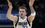 Dallas Mavericks guard Luka Doncic lobs the ball at the basket after play was called dead following a foul in the second half of an NBA basketball gam