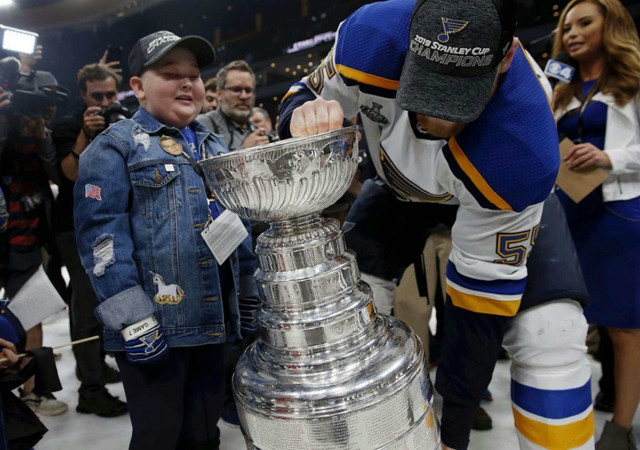St. Louis Blues fan Laila Anderson, 11, watches Colton Parayko lift the Stanley Cup while the team celebrated on the ice. The Blues "adopted" Laila, who has a life-threatening immune disease, and made her part of the entourage in Boston for Game 7.
