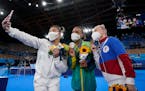 A very 2021 moment: Masks, selfies and some impromptu bonding. From left, gold medalist Suni Lee of St. Paul, Brazil’s Rebeca Andrade and Russian An