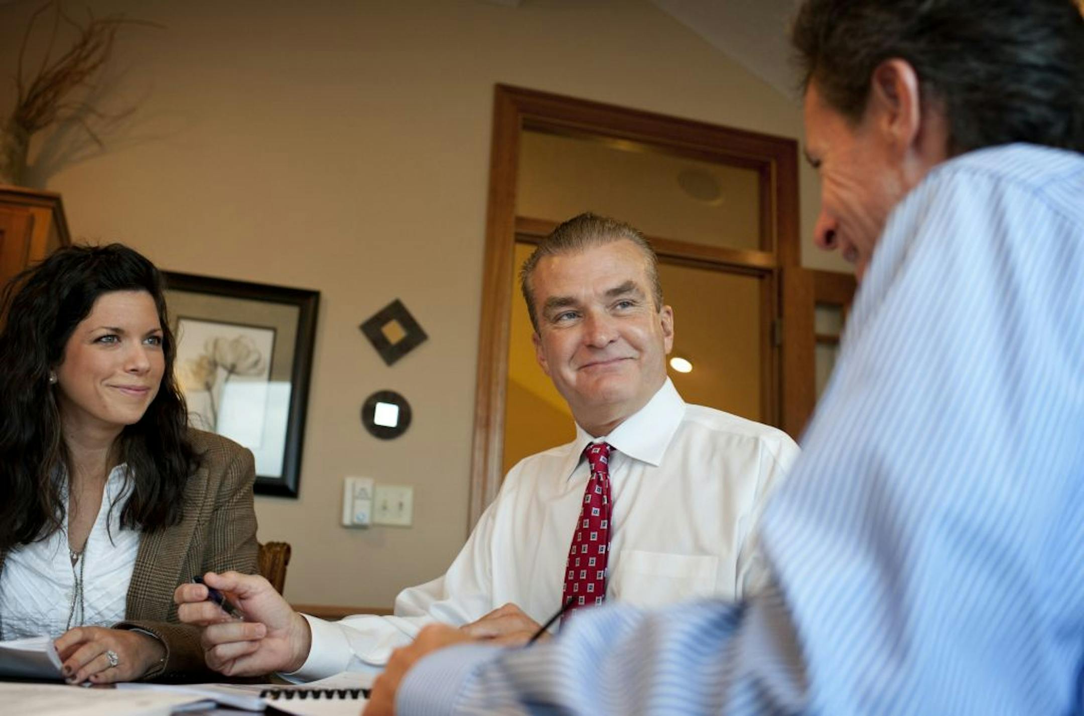 Al Kline, center, president of The Appraisal Group, Maple Grove, discussed the final revisions of a new appraisal design with office manager Lauren Bertilson and senior v.p. Paul Grace.