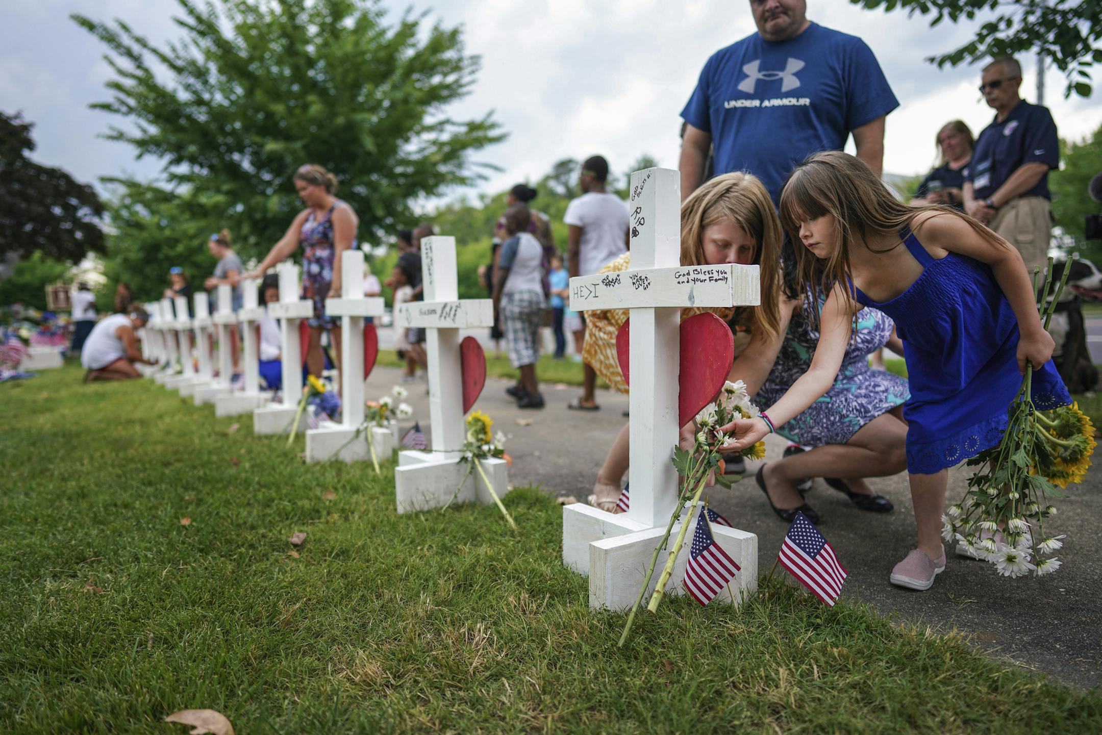 Kelly Fowler, a state delegate who represents parts of Virginia Beach, with her daughters Sophie, right, and Tessa at a makeshift memorial for the victims of the shooting in Virginia Beach, Va., June 2, 2019. The Virginia Beach city employee who killed 12 people Friday afternoon at the municipal office building had submitted his resignation hours earlier, the local authorities said on Sunday. (Chang W. Lee/The New York Times)