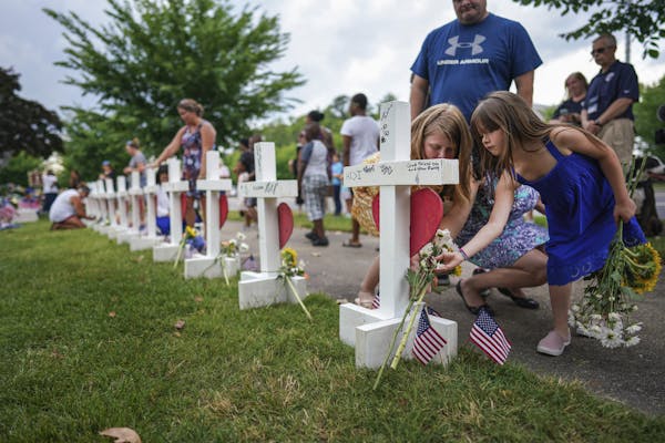 Kelly Fowler, a state delegate who represents parts of Virginia Beach, with her daughters Sophie, right, and Tessa at a makeshift memorial for the vic