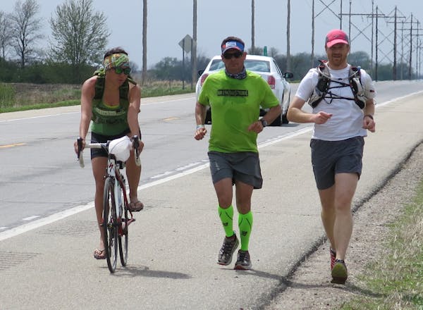 Alex Eichman, left, and Ryan Carter, right, ran with Julio Salazar along Hwy. 212 near Willmar on May 5.