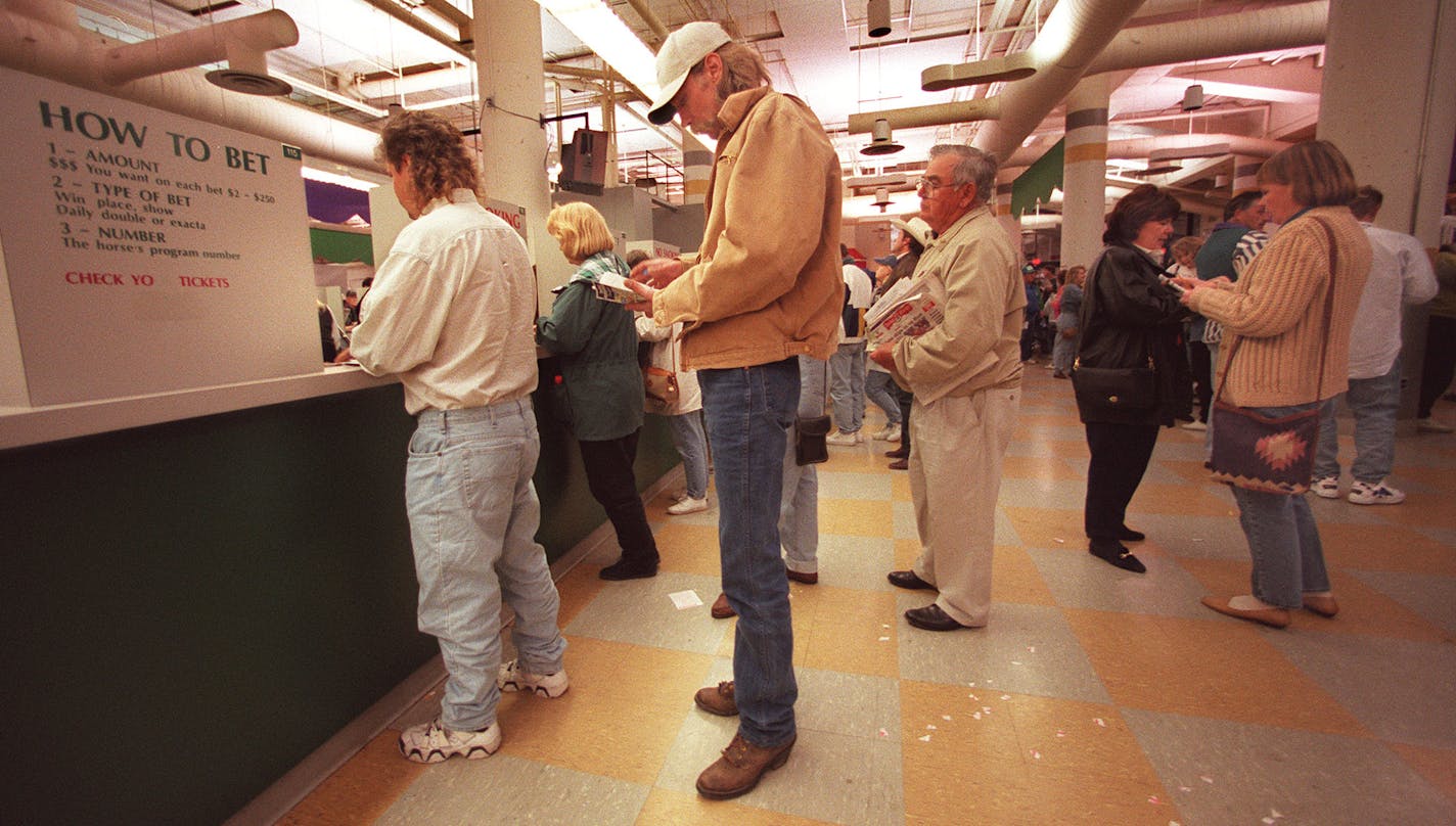 BETTORS LINE UP AT THE WAGER WINDOWS TO PLACE THEIR BETS DURING A RECENT CANTERBURY RUN .