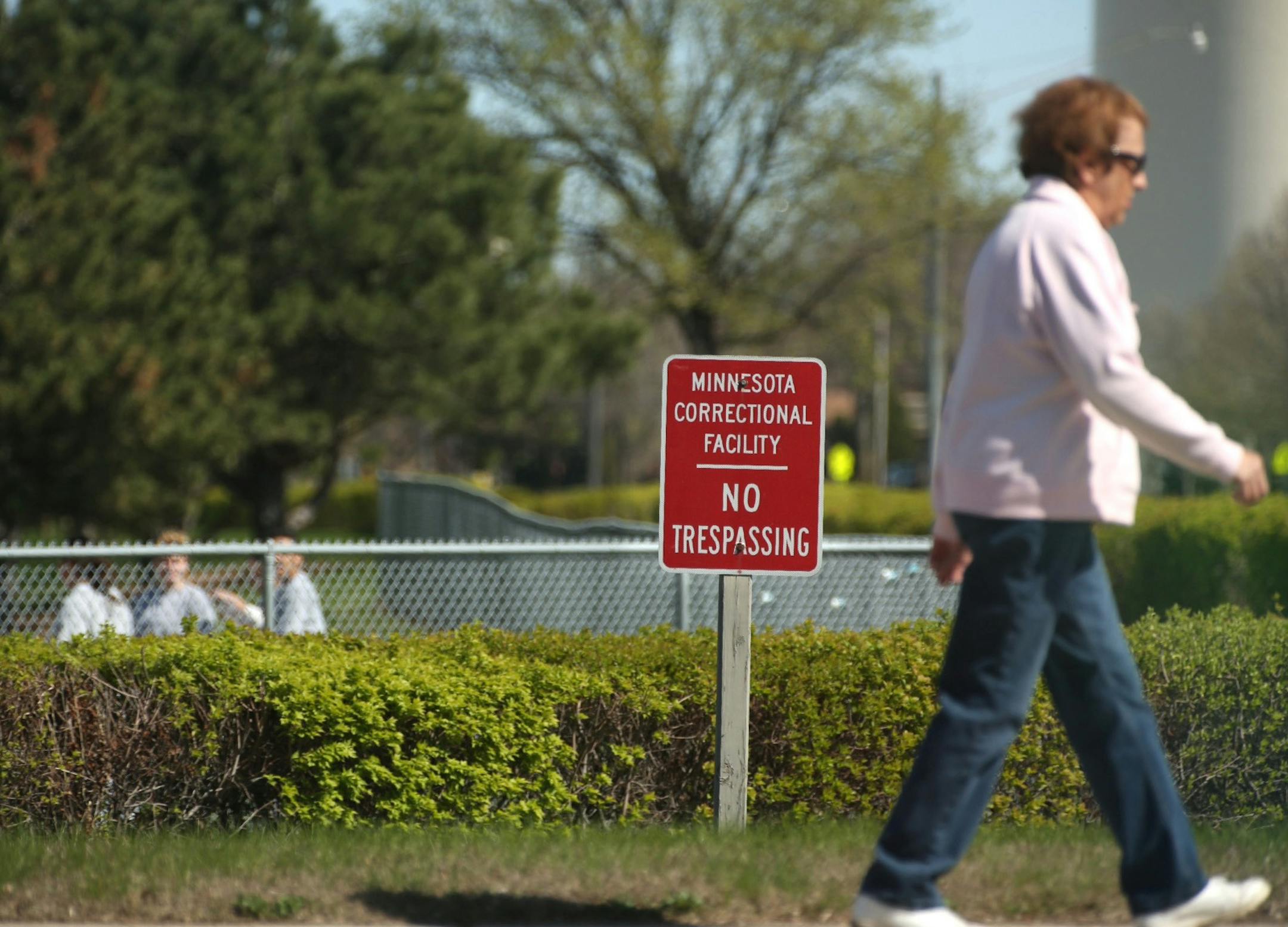 A woman walked past the Minnesota correctional facility for women in Shakopee, Minn. on April 3, 2012. Instead of a fenced property the women's prison has a hedge and short fence. At that point in the day a group of women were playing softball on the prison property. (RENEE JONES SCHNEIDER * reneejones@startribune.com) ORG XMIT: MIN2013120515345440