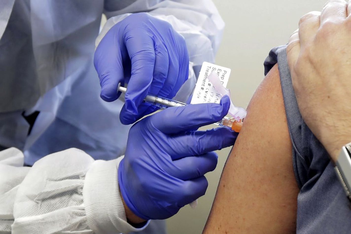 FILE - In this Monday, March 16, 2020 file photo, Neal Browning receives a shot in the first-stage safety study clinical trial of a potential vaccine for COVID-19, the disease caused by the new coronavirus at the Kaiser Permanente Washington Health Research Institute in Seattle.