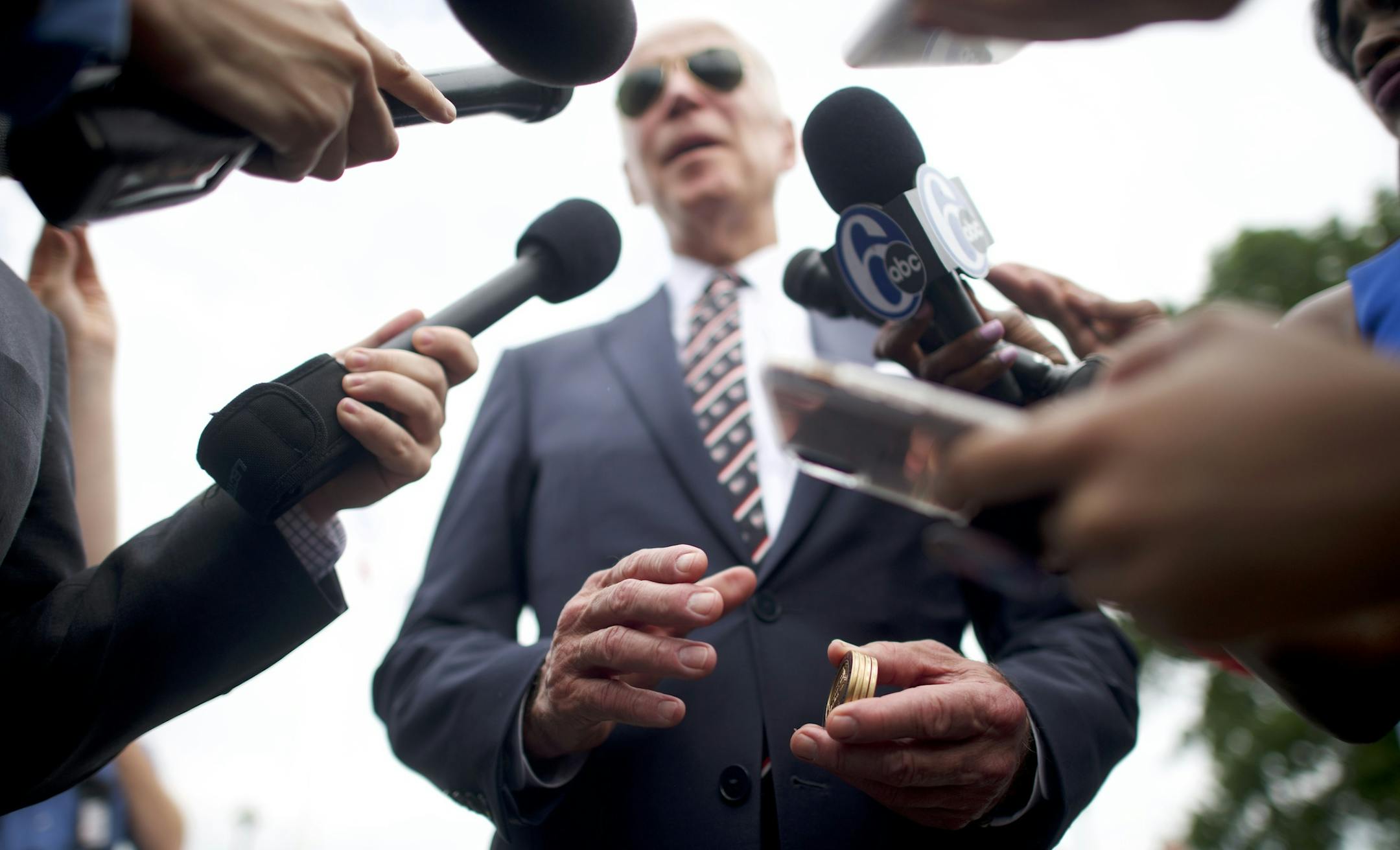 Former Vice President Joe Biden holds challenge coins while speaking to reporters after a Veterans Memorial Day service in New Castle, Del., May 30, 2019. (Mark Makela/The New York Times)