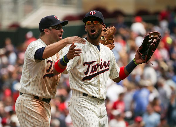 Twins second baseman Brian Dozier massaged the shoulders of left fielder Eddie Rosario as they walked off the field after their win Wednesday afternoo