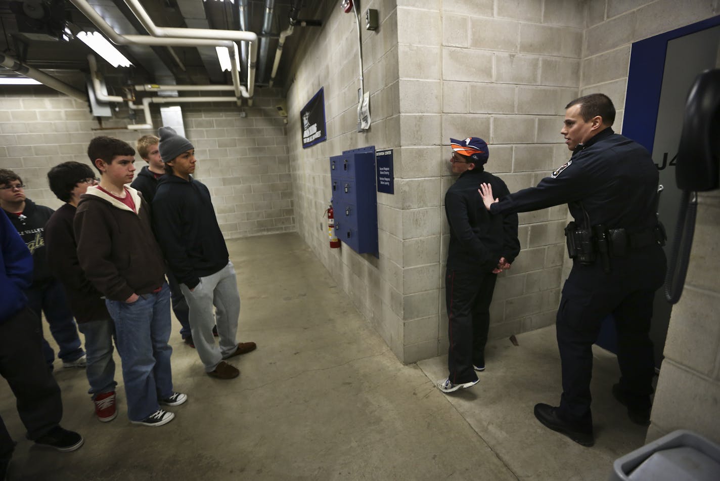 Officer David Engel demonstrated how to restrain someone on student Jon Epperson, 15, during a Teen Police Academy tour of where people are booked at the Apple Valley Police Department on Tuesday, March 19, 2013, in Apple Valley, Minn. The Apple Valley Police Department holds a Teen Police Academy each Jan. through March for about 20 teens who are interested in law enforcement. ] (RENEE JONES SCHNEIDER * reneejones@startribune.com) Jon epperson CQ