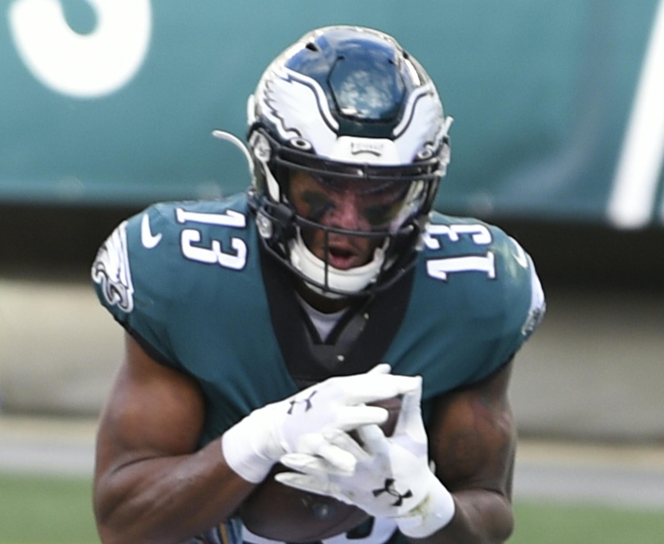 Philadelphia Eagles' Travis Fulgham (13) catches a touchdown pass against Baltimore Ravens' Marlon Humphrey (44), Marcus Peters (24) and Chuck Clark (36) during the second half of an NFL football game, Sunday, Oct. 18, 2020, in Philadelphia. (AP Photo/Derik Hamilton)