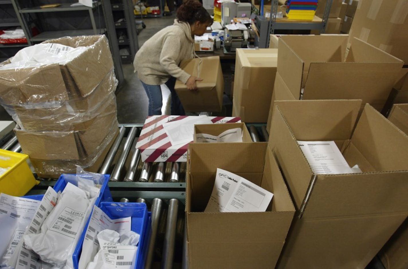 St. Paul, MN 12/27/2002 Paulette Lutter, shipping supervisor at Colder Products, packs up products going out today for customers in Germany, France and Japan. ( Colder makes plastic fluid-control devices used in a variety of applications from medical equipment to milk-shake machines).