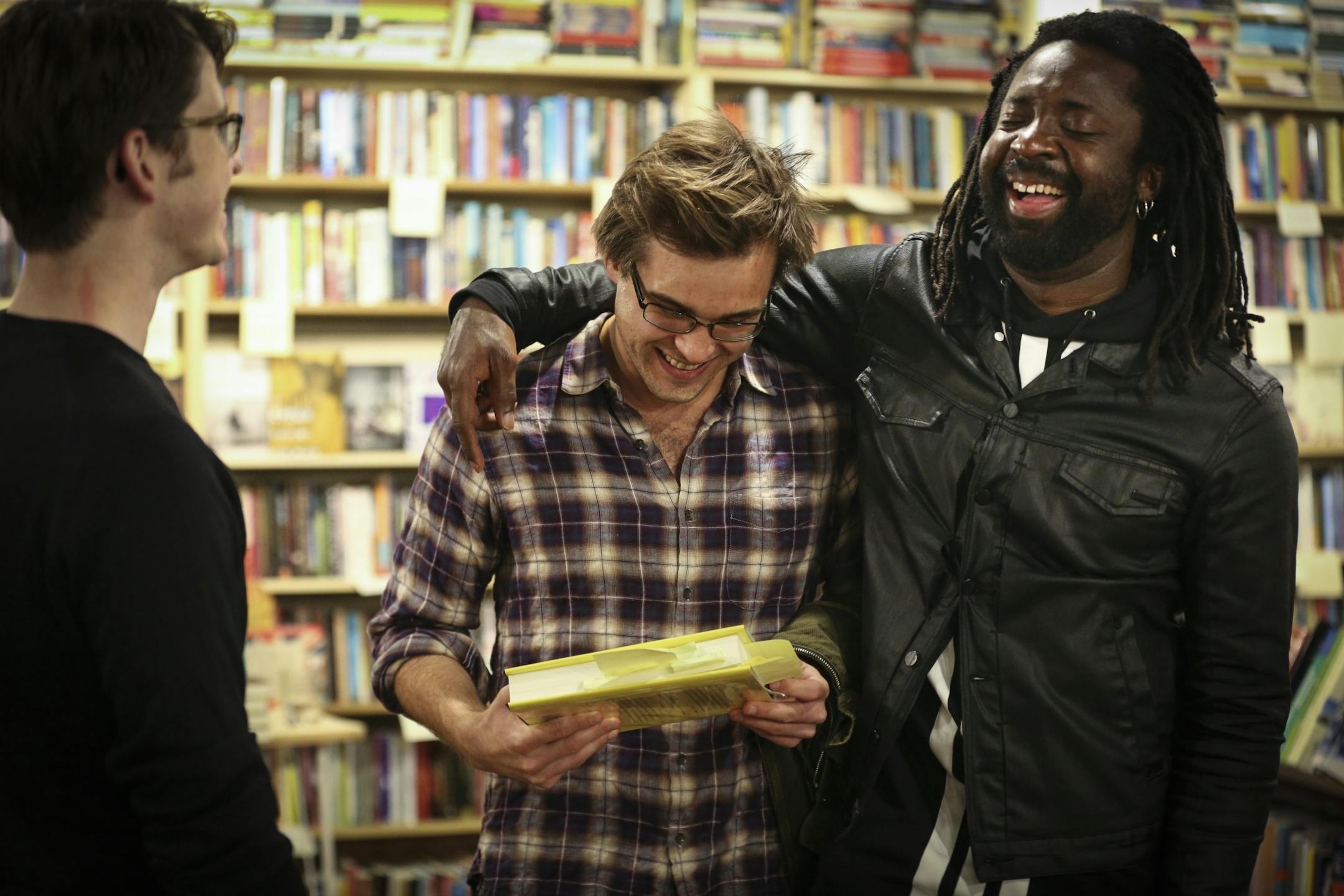 Author Marlon James put his arm around his former student and fellow writer Jeff Bennett after a reading of his new book "A Brief History of Seven Killings" at Common Good Books on Wednesday, October 3, 2014 in St. Paul, Minn.