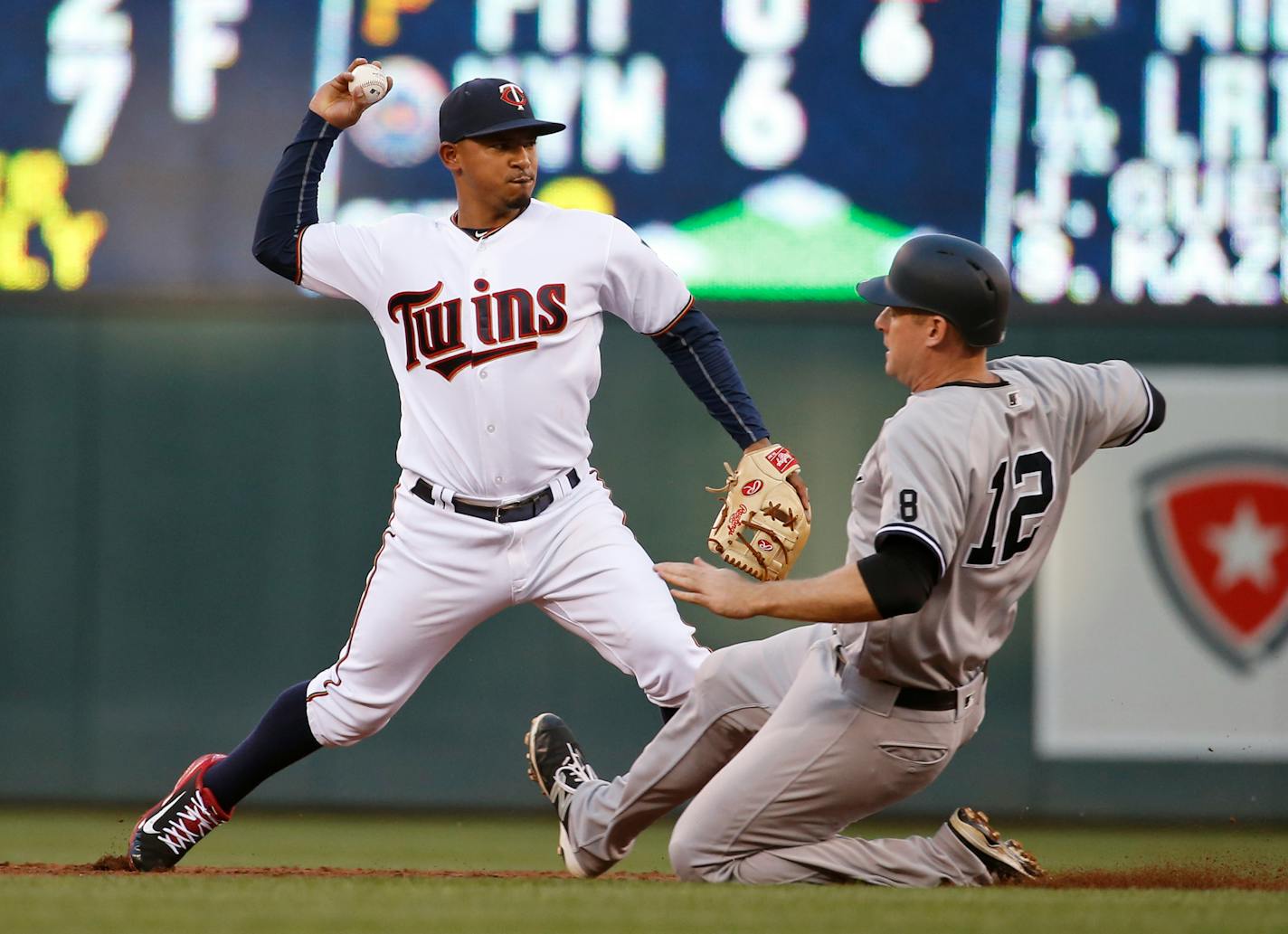 Minnesota Twins shortstop Eduardo Escobar, left, makes the throw to first to turn a double play after forcing out New York Yankees' Chase Headley (12) at second base during the third inning of a baseball game in Minneapolis, Thursday, June 16, 2016. The Yankees' Ike Davis hit into the play. (AP Photo/Ann Heisenfelt)