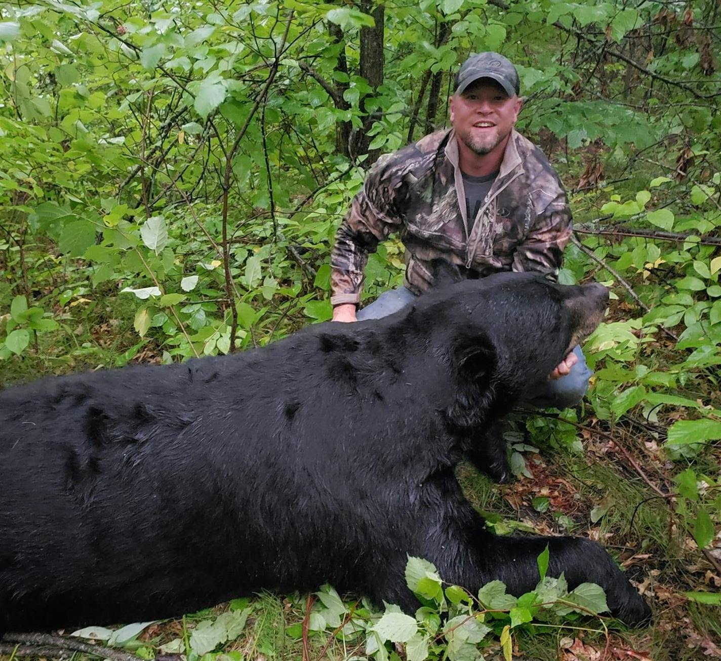 A photo that circulated on Facebook showed Brett Stimac posing with the bear federal authorities say was illegally killed.