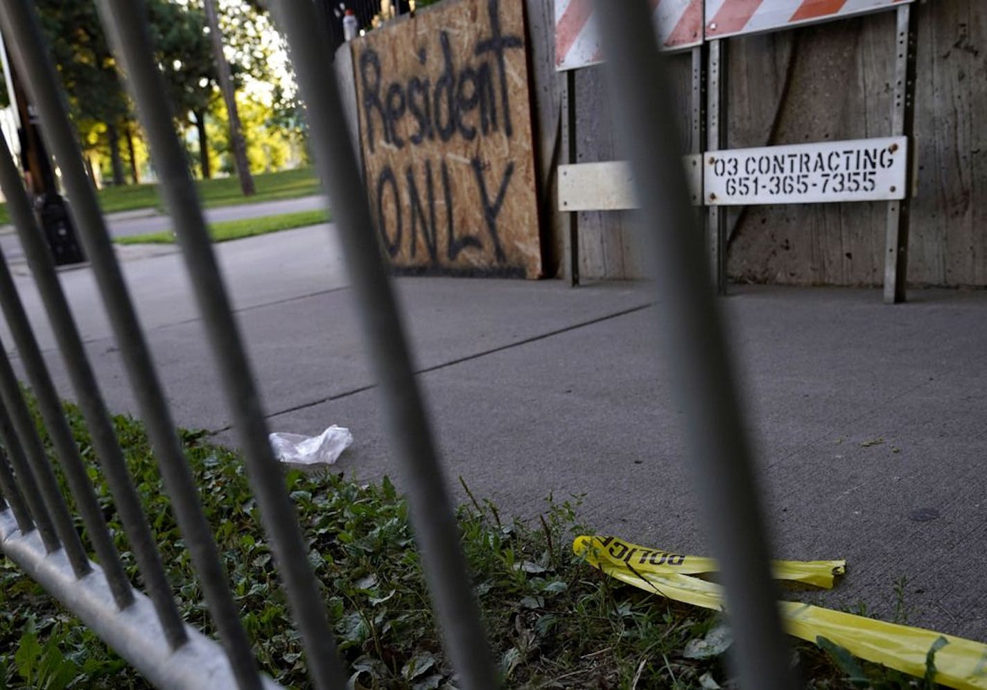 Police searched late Wednesday for at least three suspects they say fatally shot a young man and wounded another near the Little Earth housing complex in Minneapolis. The victims were struck by gunfire just after 11 p.m. in the 2400 block of S. 18th Avenue. Here, police tape is visible on the ground, across from East Phillips Park Thursday in Minneapolis.