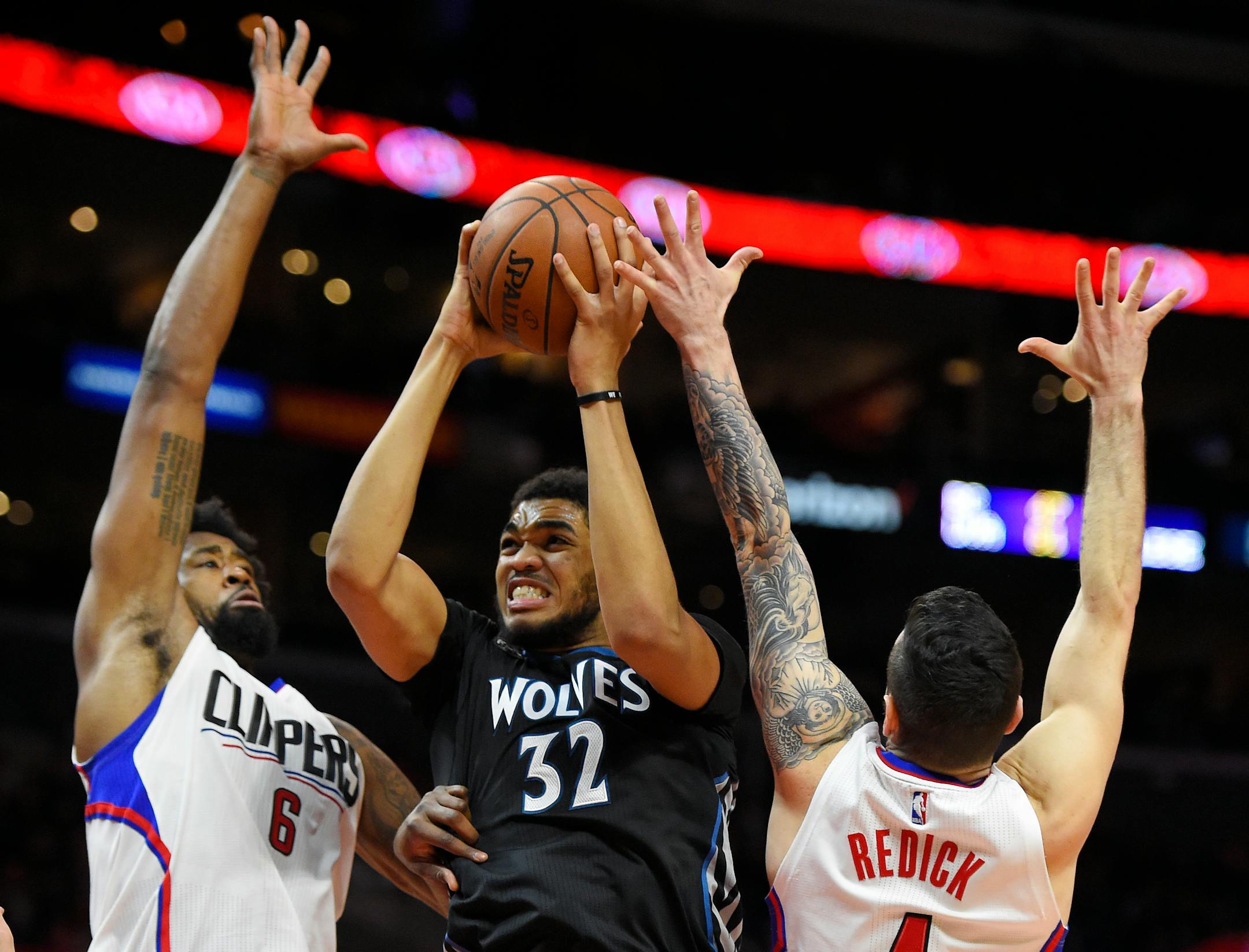 Minnesota Timberwolves center Karl-Anthony Towns, center, shoots as Los Angeles Clippers center DeAndre Jordan, left, and guard J.J. Redick defends during the second half of an NBA basketball game, Wednesday, Feb. 3, 2016, in Los Angeles. The Timberwolves won 108-102. (AP Photo/Mark J. Terrill)
