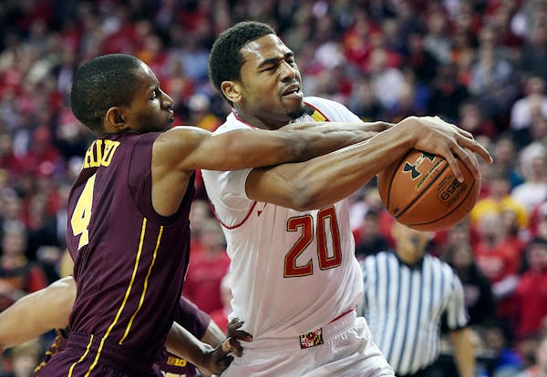 Maryland guard Richaud Pack, right, drives to the basket as Minnesota guard Deandre Mathieu defends during the first half of an NCAA college basketbal