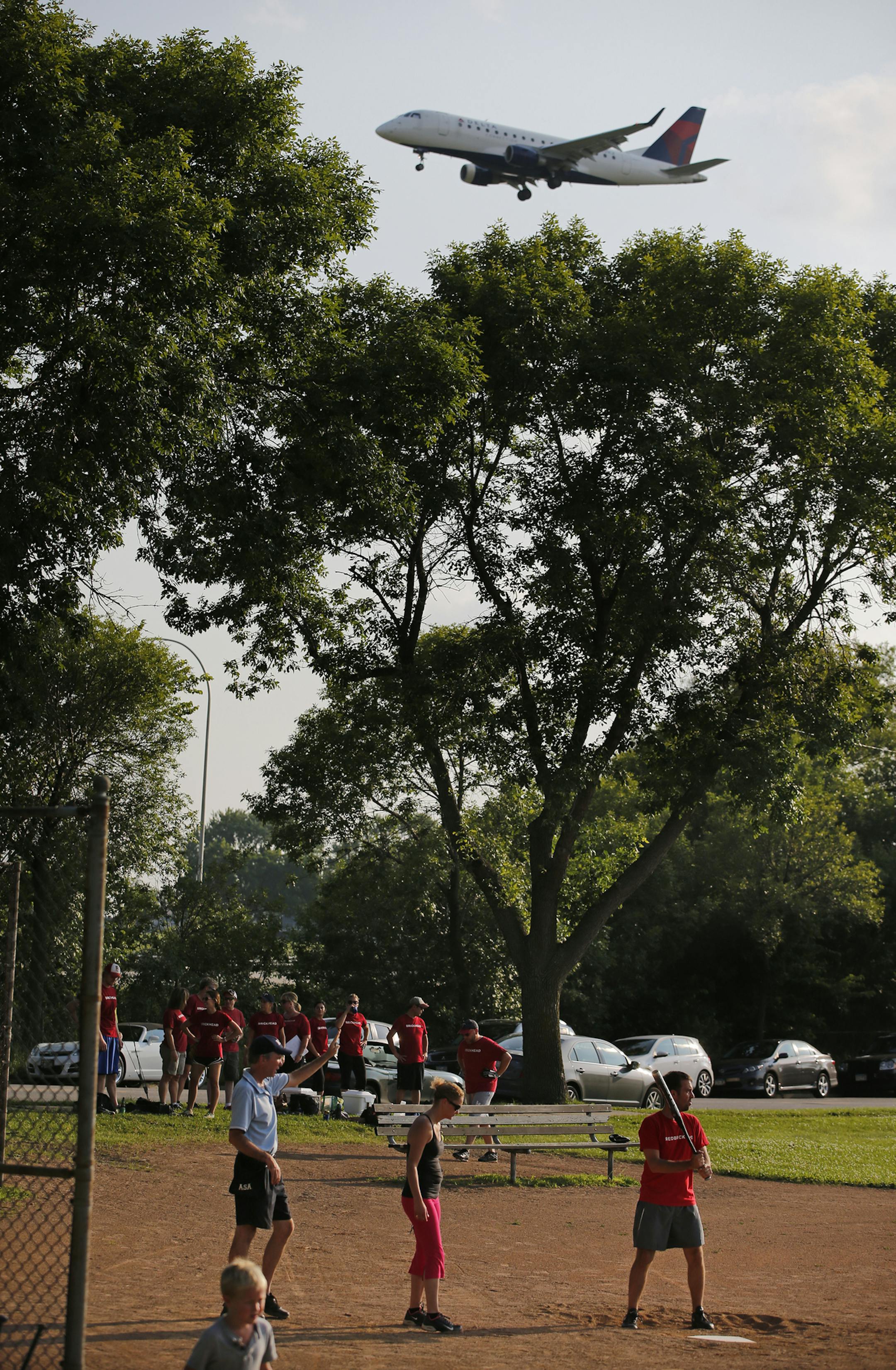 In South Minneapolis, an increase of 13% in evening plane traffic has raised the cackles of some residents. These softball players at Bossen Field Park are used to the noise .] Richard Tsong-Taatarii/rtsong-taatarii@startribune.com ORG XMIT: MIN1507142101540335