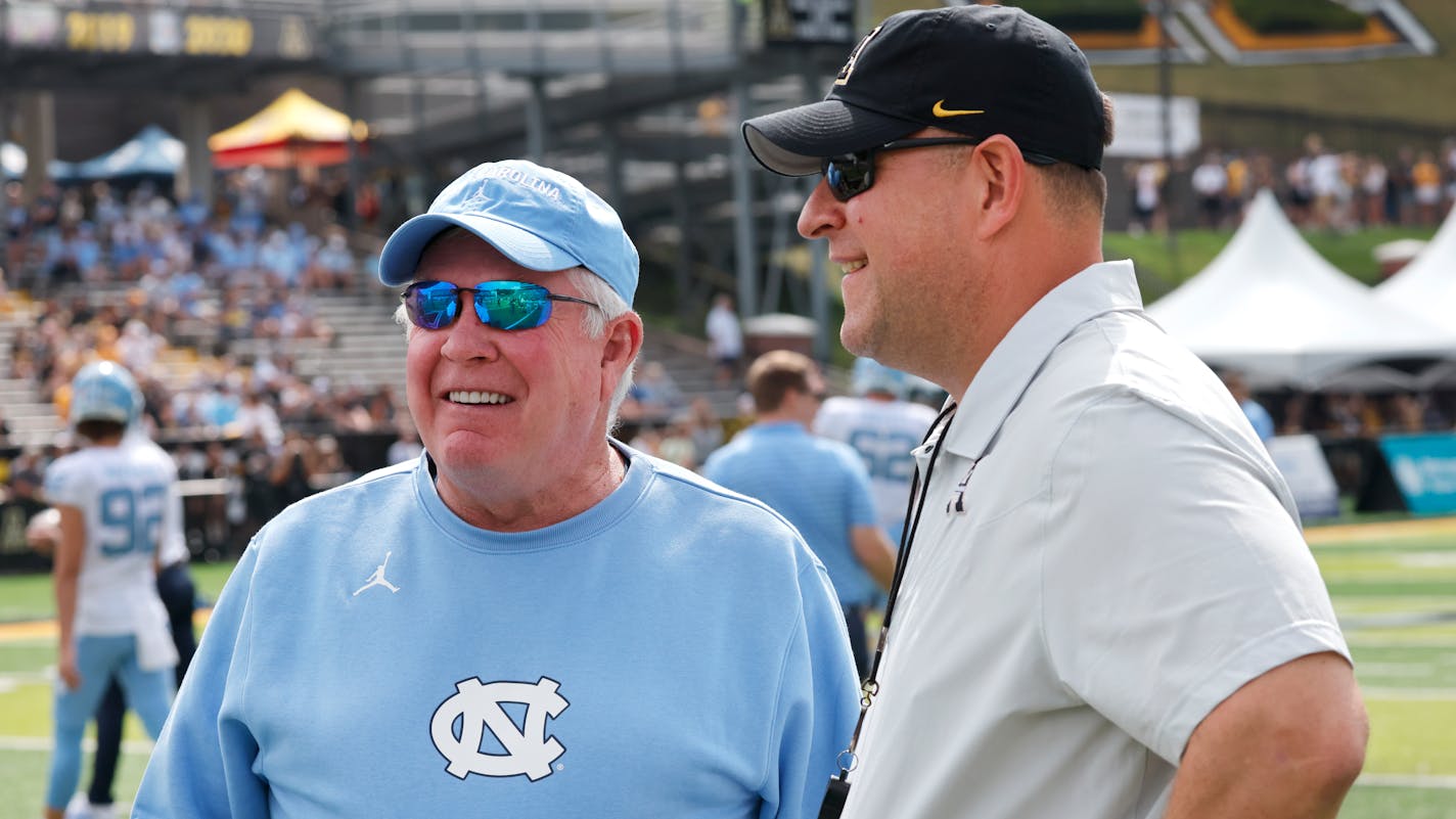 North Carolina head coach Mack Brown and Appalachian State head coach Shawn Clark talked before a football game Sept. 3.