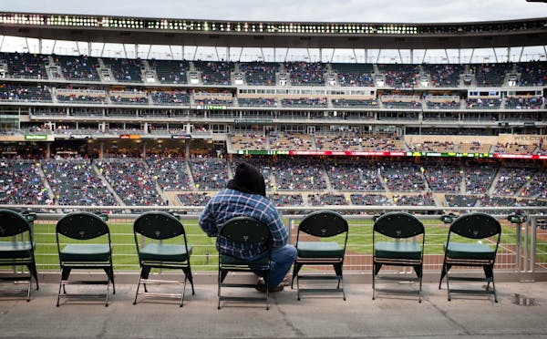 The lights came on early at Target Field as clouds and drizzle rolled in Thursday afternoon. Empty seats were abundant.