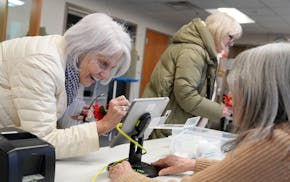 Marta Lukasewycz of Edina fills out information before voting in the presidential primary.