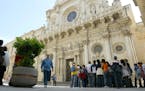 Tourists visit the Santa Croce Basilica in Lecce, in southern Italy's Puglia region, Friday April 20, 2007. Puglia has the brightest sea, the most div