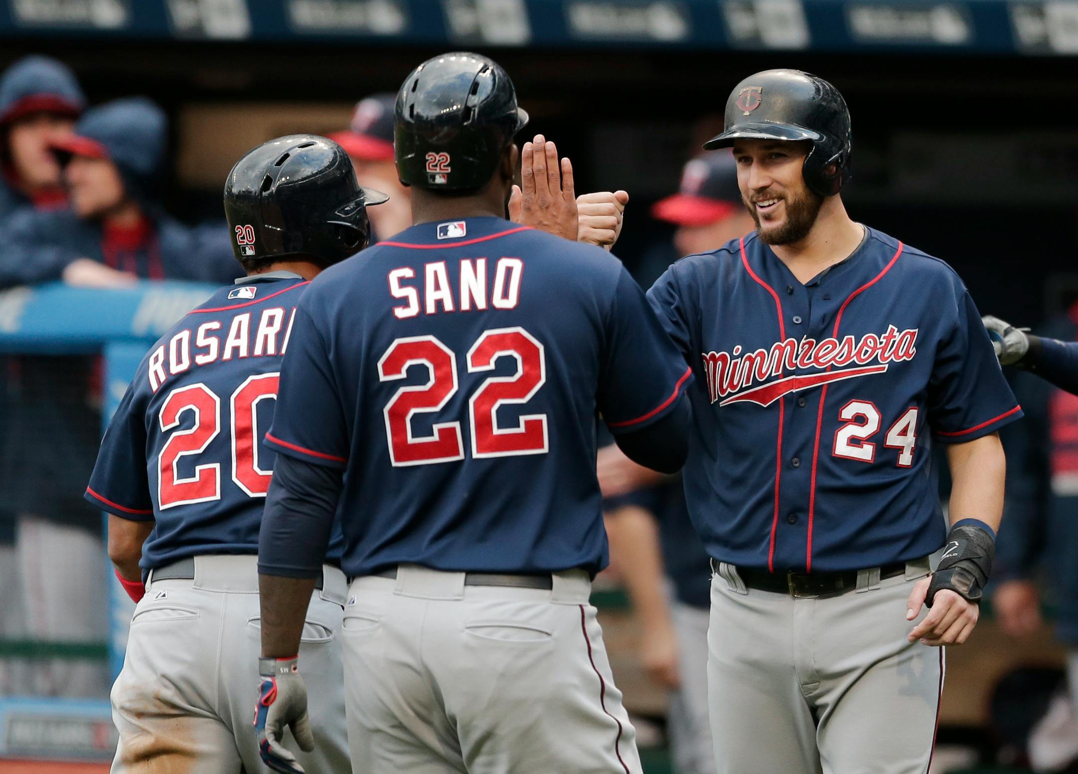Minnesota Twins' Trevor Plouffe (24) congratulates Eddie Rosario (20) and Miguel Sano (22) after all three scored on a three-RBI double by Torii Hunter in the fourth inning of the first baseball game of a doubleheader against the Cleveland Indians, Wednesday, Sept. 30, 2015, in Cleveland. (AP Photo/Tony Dejak)