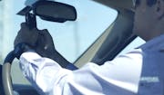 A man looks at his phone while driving down Woodall Rodgers Freeway on July 16, 2015, in Dallas. The United States is leading the world in increased t