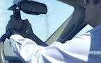 A man looks at his phone while driving down Woodall Rodgers Freeway on July 16, 2015, in Dallas. The United States is leading the world in increased t