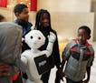 Josiah Adjei, 6, right, gave a closer look to Pepper the humanoid robot as he, his siblings and cousins took a group photo in the Mall of America's ro