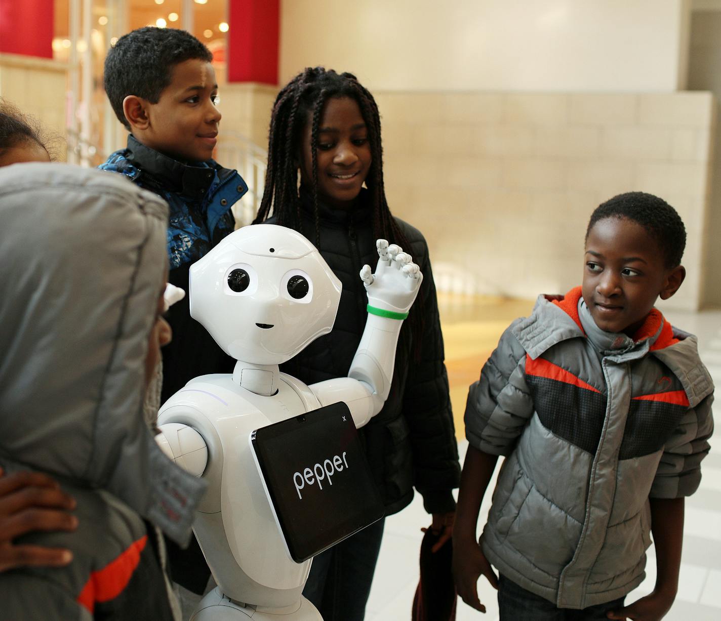 Josiah Adjei, 6, right, gave a closer look to Pepper the humanoid robot as he, his siblings and cousins took a group photo in the Mall of America's rotunda Wednesday afternoon. ] ANTHONY SOUFFLE &#xef; anthony.souffle@startribune.com Pepper, a humanoid robot, interacted with shoppers Wednesday, Feb. 21, 2018 at the Mall of America in Bloomington, Minn.