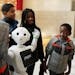 Josiah Adjei, 6, right, gave a closer look to Pepper the humanoid robot as he, his siblings and cousins took a group photo in the Mall of America's ro