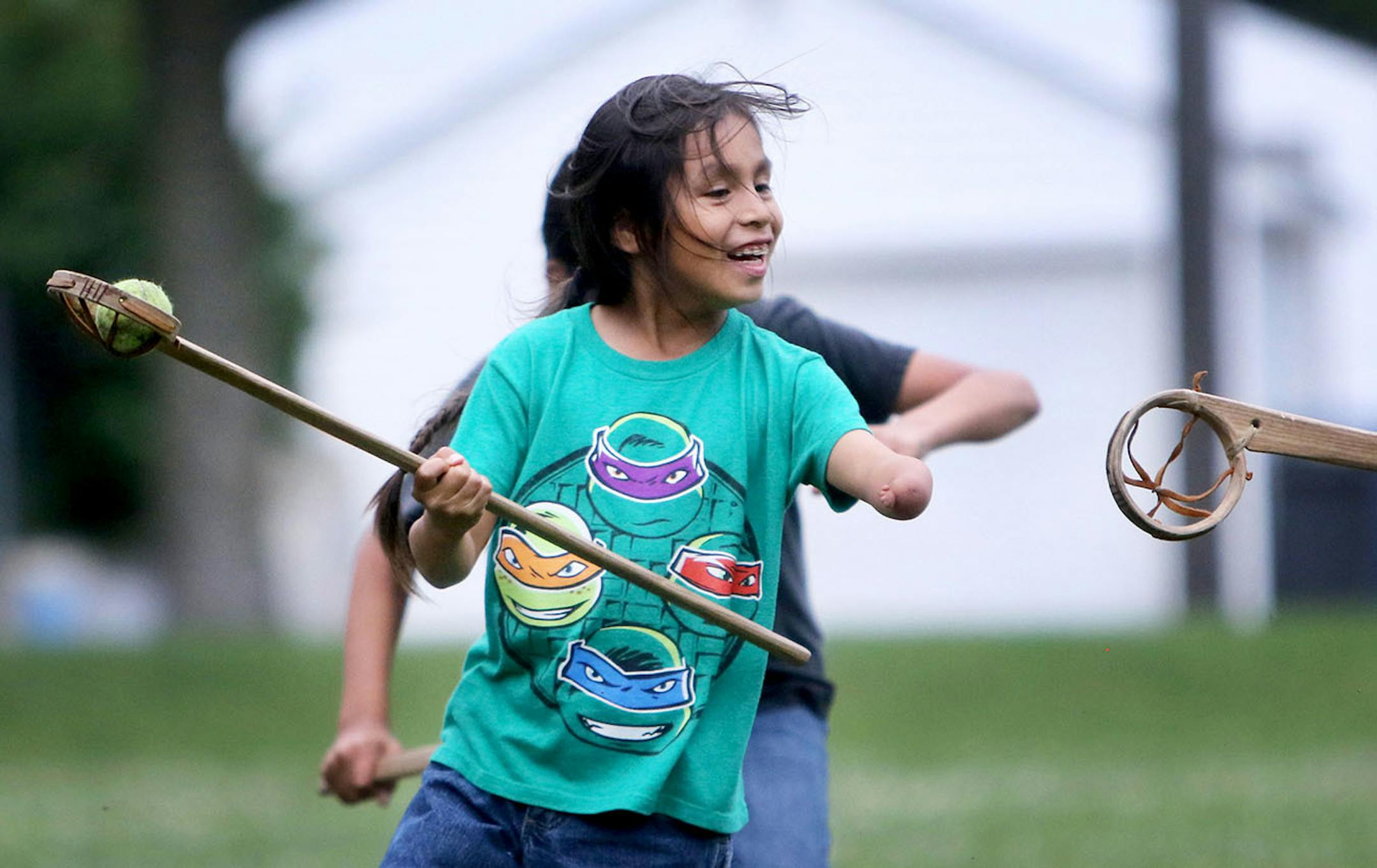 Youth members of Twin Cities Native Lacrosse practice at Corcoran Park Wednesday, June 17, 2015, in Minneapolis, MN. The traditional Lacrosse players, who play with hand carved ash sticks, were preparing for the upcoming Twin Cities Native Lacrosse Tournament at the Osseo High School Saturday. Here, Wakinyan DeCory looks to pass while being covered.