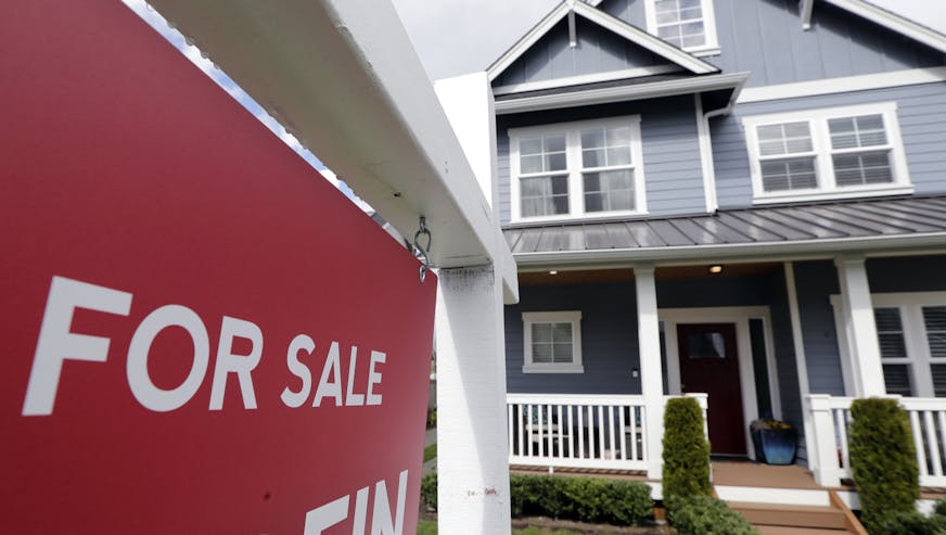 FILE - In this April 1, 2020 photo, a "For Sale" sign stands in front of a home that is in the process of being sold in Monroe, Wash., outside of Seattle. U.S. home sales rose a record-breaking 24.7% in July, extending last month's rebound after the coronavirus pandemic all but froze the housing market this spring, the National Association of Realtors said Friday, Aug. 21, 2020. (AP Photo/Elaine Thompson, File)