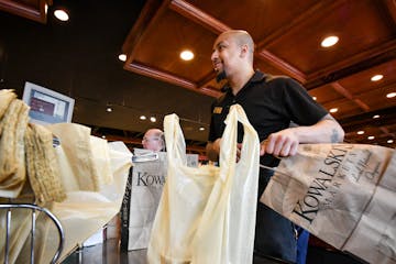 Kowalski's employee bags groceries.